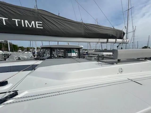 About Time Yacht Photos Pics 2021 Leopard 45 catamaran with sleek deck and sail, docked at marina.