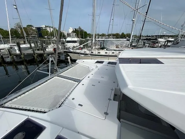 About Time Yacht Photos Pics 2021 Leopard 45 catamaran docked at marina, featuring spacious deck and netting.