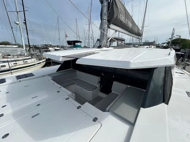 About Time Yacht Photos Pics 2021 Leopard 45 catamaran with sleek design, docked in a marina, featuring spacious deck and seating.