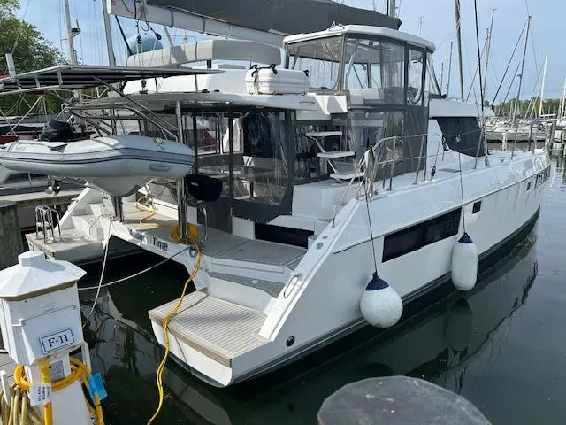 About Time Yacht Photos Pics 2021 Leopard 45 catamaran docked at marina with dinghy and fenders.