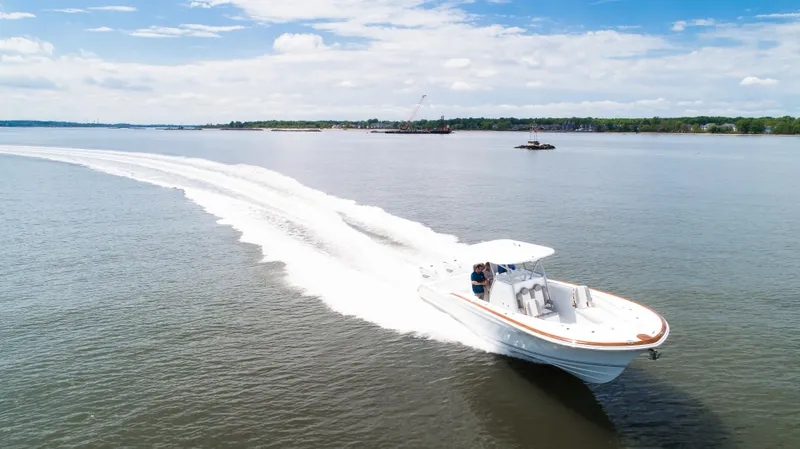 Yacht Photos Pics 2025 Buddy Davis 34 Center Console speeding on open water under blue sky.