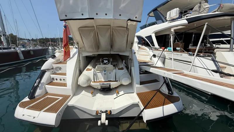  Yacht Photos Pics 2006 Sunseeker Portofino 53 yacht docked, showcasing rear view and open storage compartment.