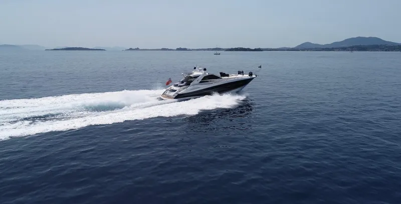  Yacht Photos Pics 2006 Sunseeker Portofino 53 yacht cruising on open water, with distant mountains.