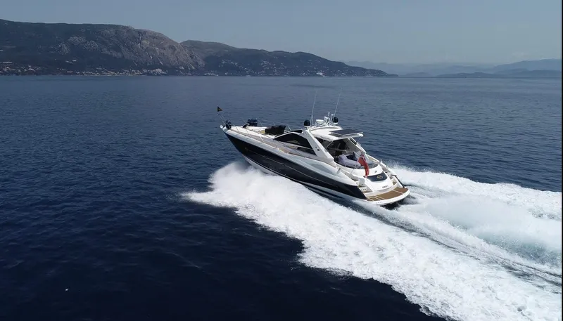  Yacht Photos Pics 2006 Sunseeker Portofino 53 yacht cruising on open sea with mountainous backdrop.