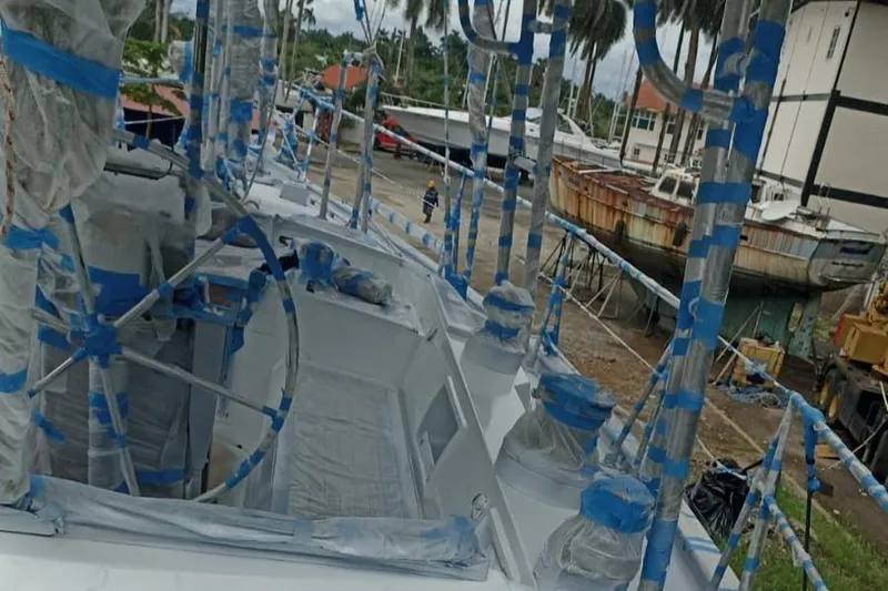 Sv Indago Yacht Photos Pics 1991 Tayana 47 CC sailboat under maintenance, wrapped in protective coverings at a boatyard.