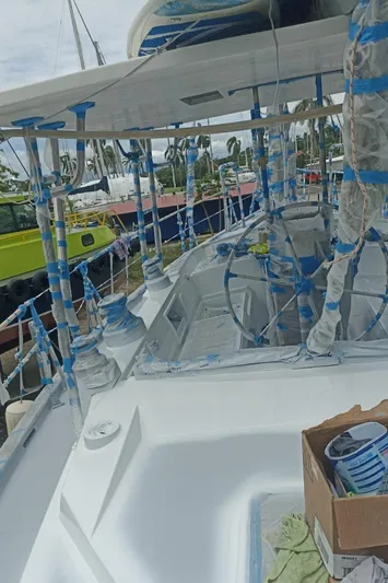 Sv Indago Yacht Photos Pics 1991 Tayana 47 CC sailboat undergoing maintenance with taped sections and paint supplies.