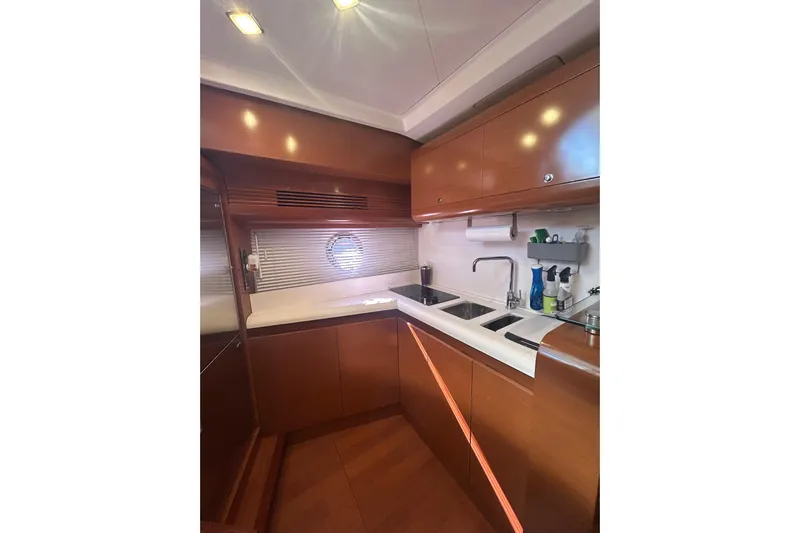  Yacht Photos Pics Interior of 2012 Beneteau Gran Turismo 44 yacht kitchen with wooden cabinetry and modern fixtures.