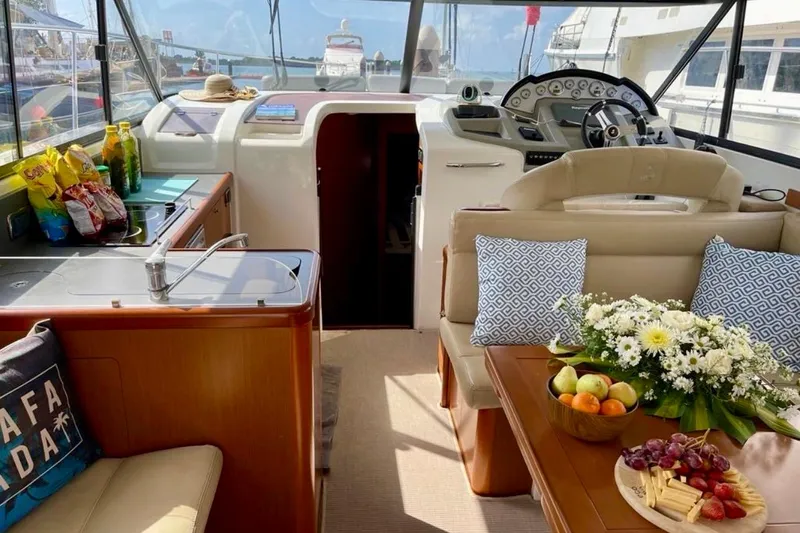  Yacht Photos Pics Interior of 2013 Beneteau Antares 42 yacht with snacks and flowers on table.
