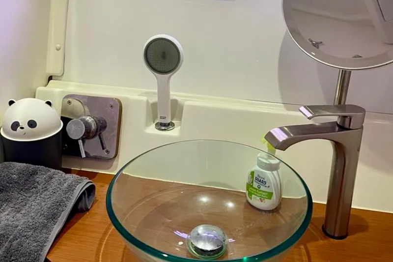  Yacht Photos Pics Bathroom sink area on 2013 Beneteau Antares 42 yacht with glass basin and panda-themed decor.