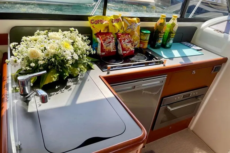  Yacht Photos Pics Kitchen area of 2013 Beneteau Antares 42 with snacks, drinks, and flowers.