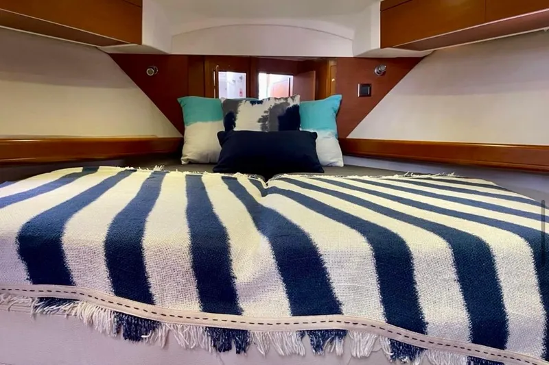  Yacht Photos Pics Cozy cabin interior of 2013 Beneteau Antares 42 with striped bedding and cushions.