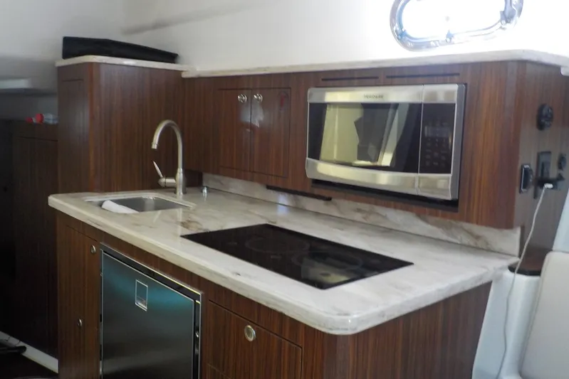  Yacht Photos Pics 2020 Pursuit OS 355 Offshore yacht kitchen with modern appliances and wood cabinetry.