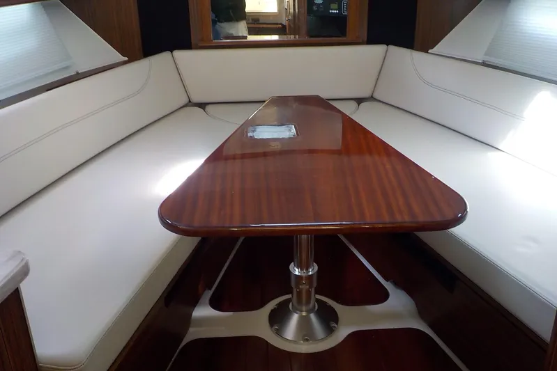 Yacht Photos Pics 2020 Pursuit OS 355 Offshore interior with elegant wooden table and cushioned seating.