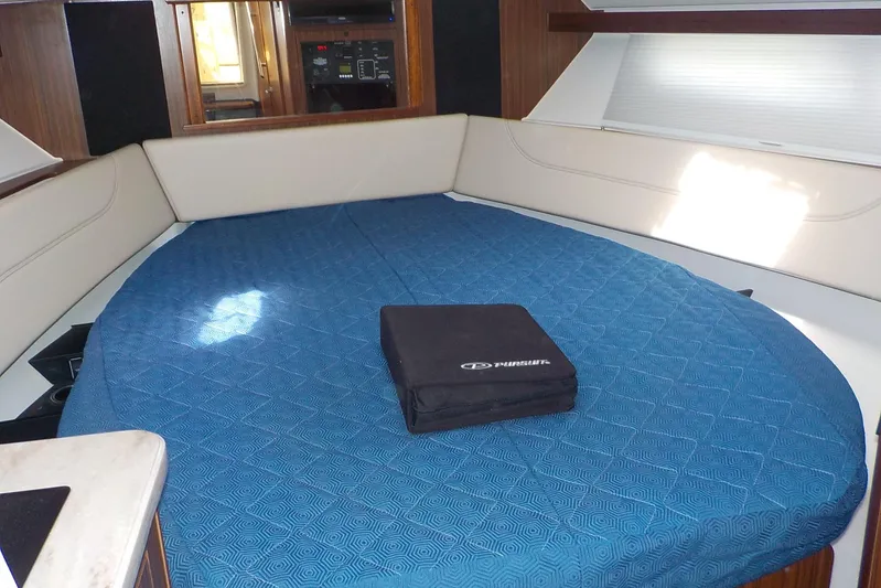  Yacht Photos Pics 2020 Pursuit OS 355 Offshore cabin interior with blue bedding and seating area.