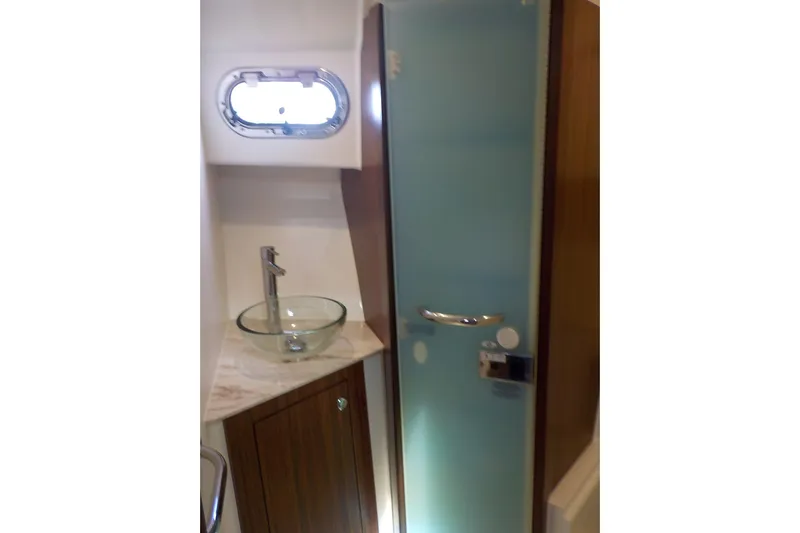  Yacht Photos Pics 2020 Pursuit OS 355 Offshore bathroom with glass sink and frosted shower door.