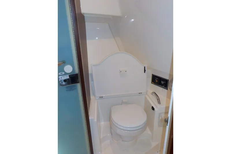  Yacht Photos Pics 2020 Pursuit OS 355 Offshore boat bathroom with compact toilet and modern fixtures.