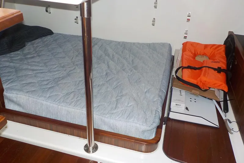  Yacht Photos Pics 2020 Pursuit OS 355 Offshore cabin with bed, life jacket, and wooden flooring.