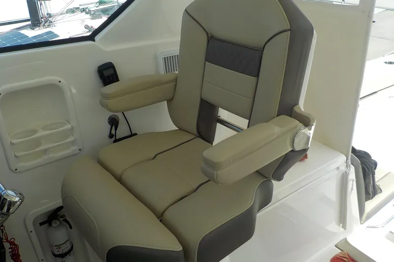  Yacht Photos Pics Captain's chair on 2020 Pursuit OS 355 Offshore boat, featuring beige and gray upholstery.