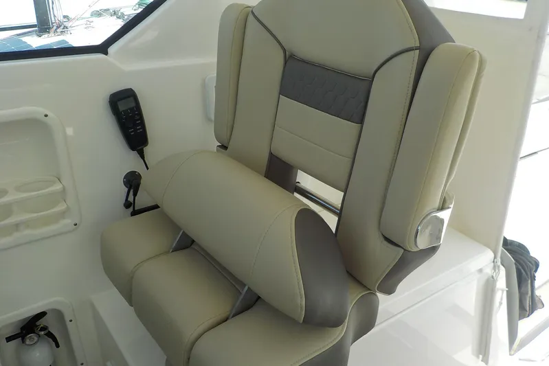  Yacht Photos Pics Captain's chair on 2020 Pursuit OS 355 Offshore boat, featuring beige and gray upholstery.