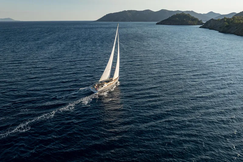 Hanse 588 Yacht Photos Pics Sailing yacht Hanse 588 (2024) cruising on open sea near scenic coastline.