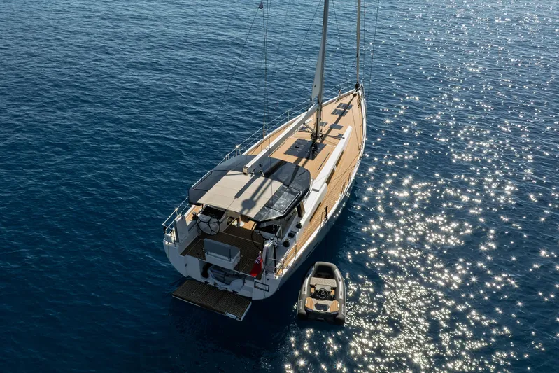 Hanse 588 Yacht Photos Pics 2024 Hanse 588 yacht on sparkling blue water with a small dinghy.