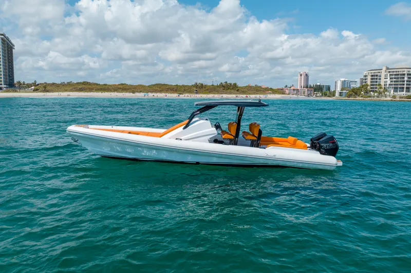 Novielli Yacht Photos Pics 2026 Novielli Veloche 349 boat on blue ocean near sandy beach and cityscape.