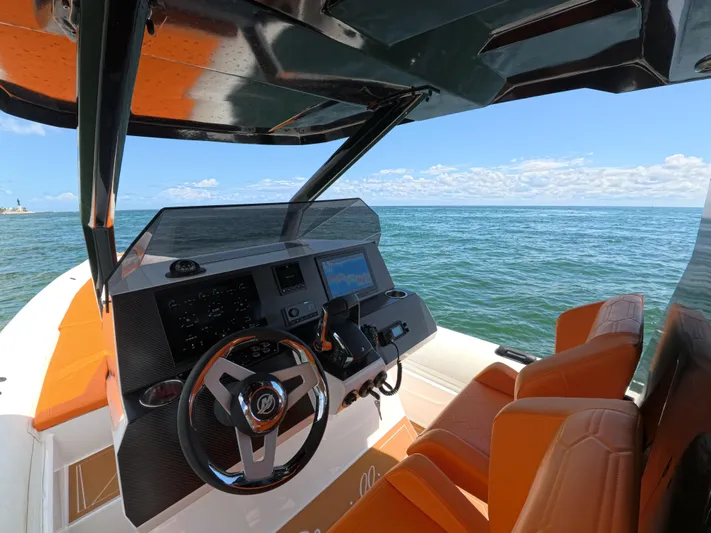 Novielli Yacht Photos Pics Cockpit of 2026 Novielli Veloche 349 boat with orange seats, steering wheel, and ocean view.