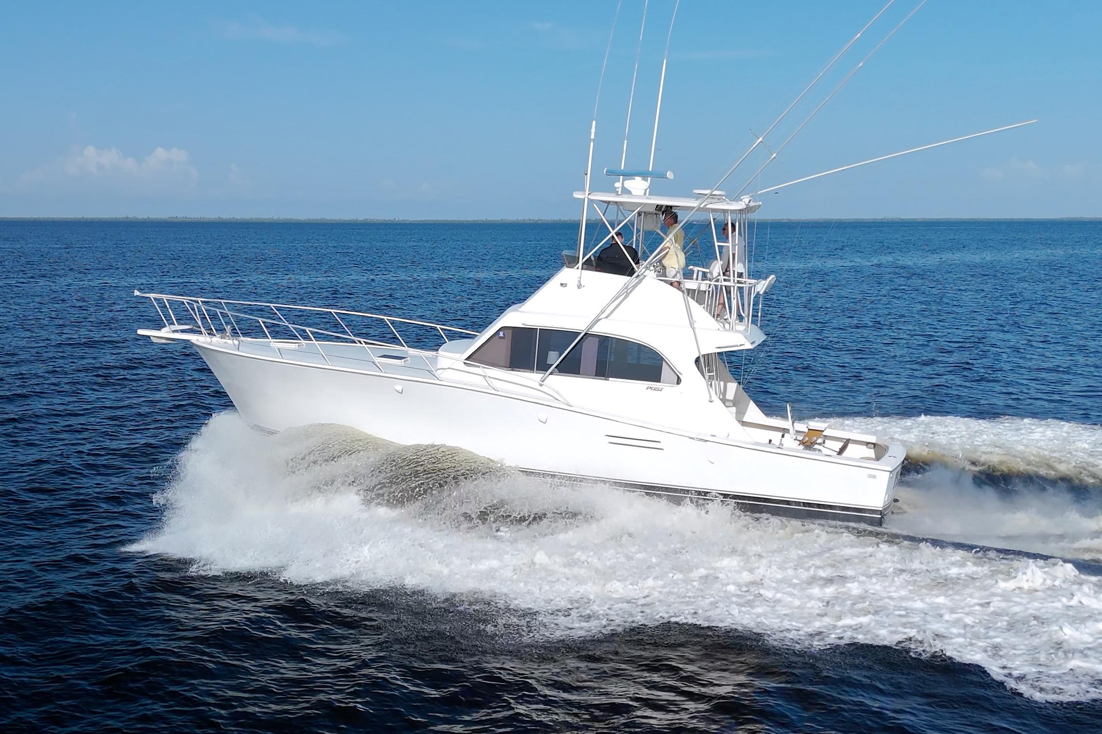1990 Post 44 Sport Fisherman cruising on open water under clear blue skies.
