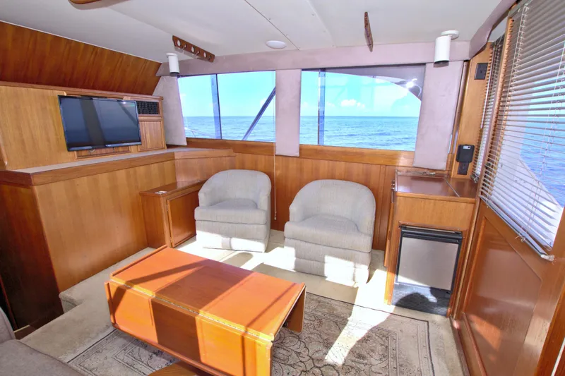 Fishin Post Yacht Photos Pics Interior of 1990 Post 44 Sport Fisherman yacht with ocean view, cozy seating, and wooden decor.