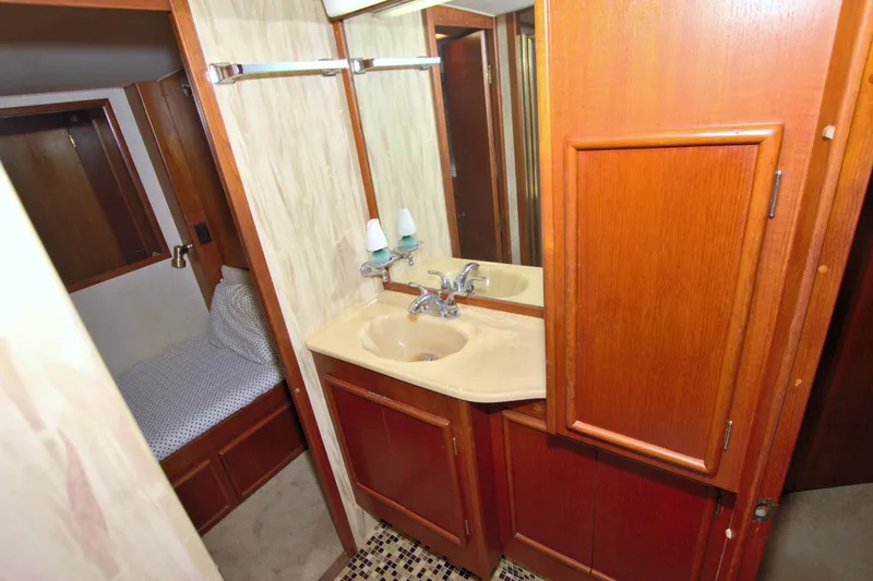 Fishin Post Yacht Photos Pics 1990 Post 44 Sport Fisherman bathroom with wooden cabinets and beige sink.