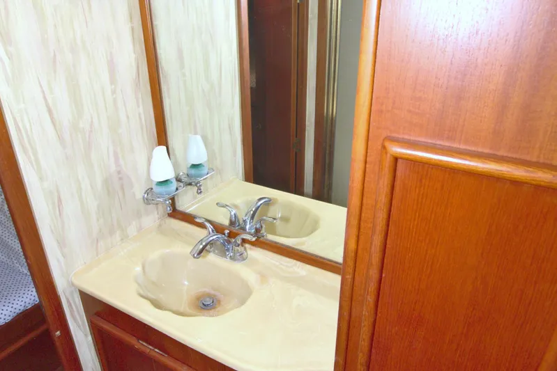 Fishin Post Yacht Photos Pics Bathroom sink area in a 1990 Post 44 Sport Fisherman yacht, featuring wood cabinetry.