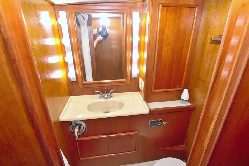 Fishin Post Yacht Photos Pics 1990 Post 44 Sport Fisherman bathroom with wooden cabinetry and illuminated mirror.