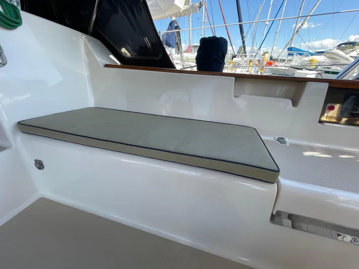  Yacht Photos Pics Island Packet 380 sailboat cockpit seating, 2002 model, with cushion and marina view.