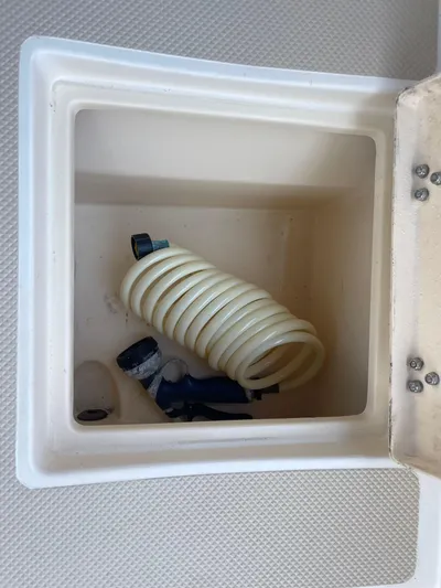  Yacht Photos Pics Storage compartment on a 2002 Island Packet 380 sailboat with coiled hose and nozzle.