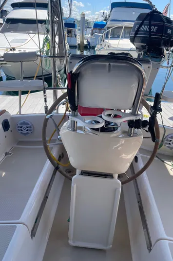  Yacht Photos Pics 2002 Island Packet 380 sailboat cockpit with steering wheel and docked boats in background.