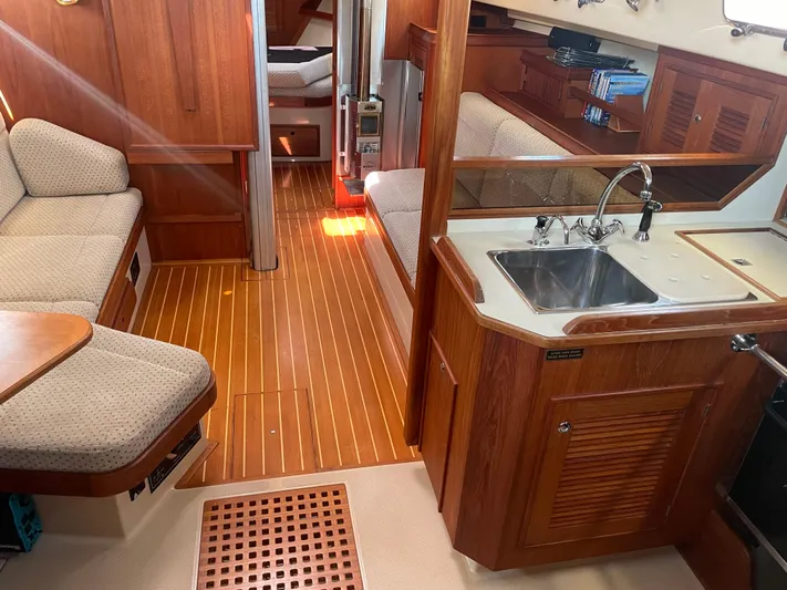  Yacht Photos Pics Interior of 2002 Island Packet 380 sailboat with wood finish and compact kitchen area.