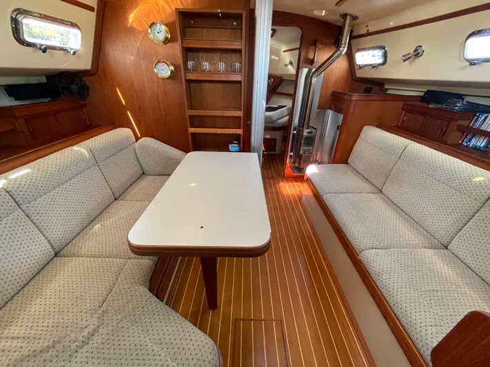  Yacht Photos Pics Interior of 2002 Island Packet 380 sailboat with cozy seating and wooden flooring.