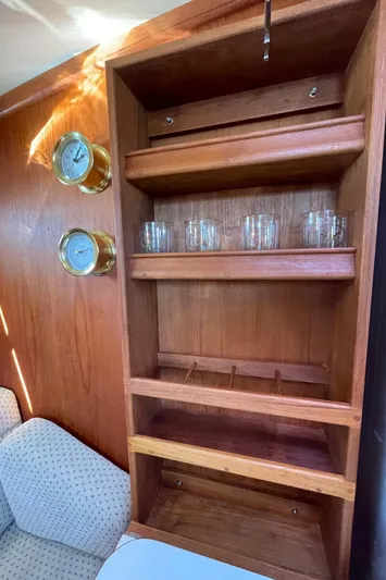  Yacht Photos Pics Wooden cabinet with glassware and gauges in a 2002 Island Packet 380 sailboat interior.
