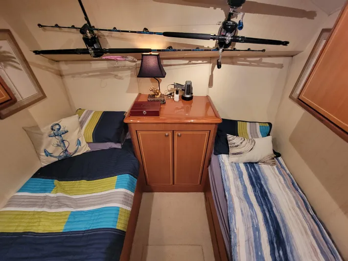  Yacht Photos Pics Cozy cabin interior of 2005 Ocean Yachts 57 Super Sport with twin beds and fishing rods.