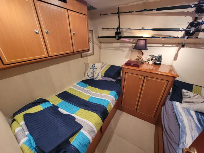  Yacht Photos Pics Cozy cabin interior of 2005 Ocean Yachts 57 Super Sport with twin beds and fishing rods.