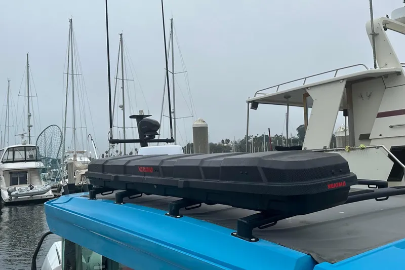License To Chill Yacht Photos Pics 2021 Axopar boat with Yakima cargo box, docked in marina with sailboats.