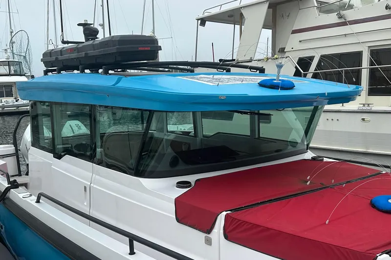 License To Chill Yacht Photos Pics 2023 Axopar Brabus boat with blue roof and red cover docked at marina.