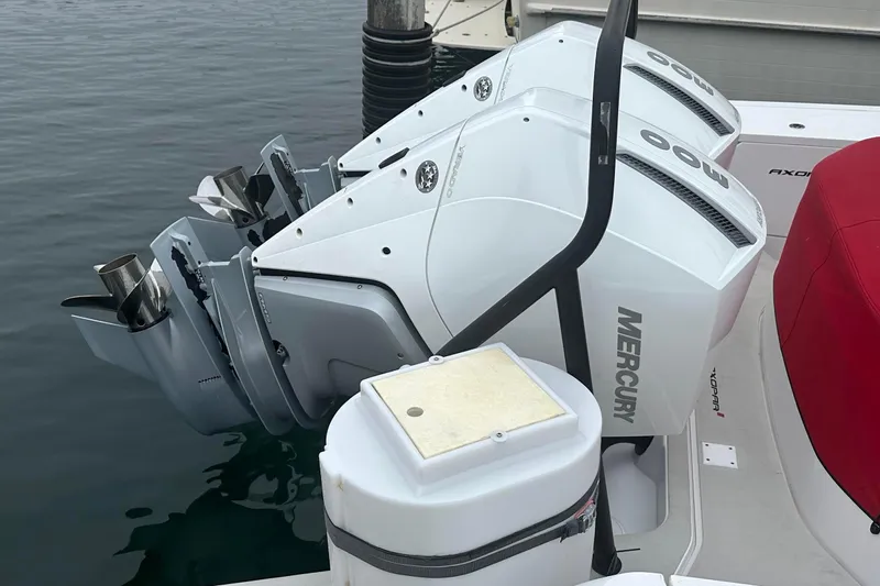 License To Chill Yacht Photos Pics Twin Mercury outboard engines on a 2023 Axopar Brabus boat, docked in calm water.
