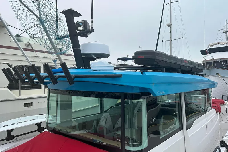 License To Chill Yacht Photos Pics 2023 Axopar Brabus boat with blue roof, fishing rod holders, and rooftop storage.