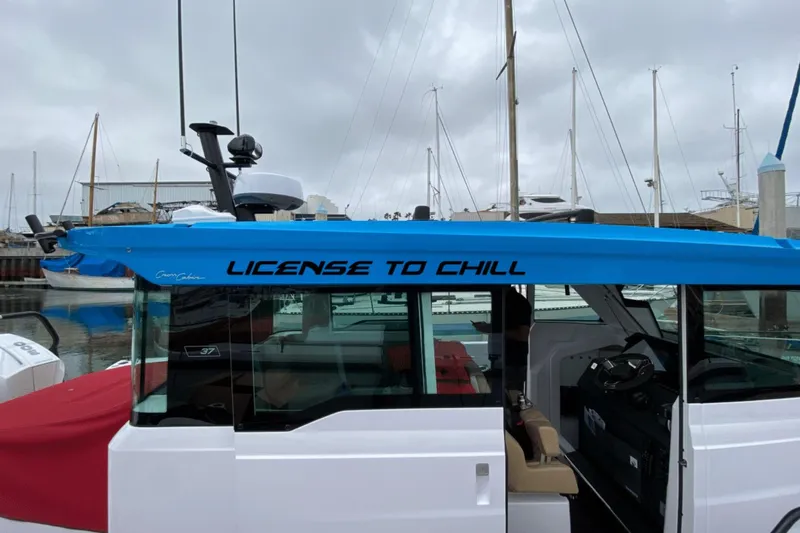 License To Chill Yacht Photos Pics 2023 Axopar boat with "License to Chill" text, featuring gull-wing doors, docked at marina.