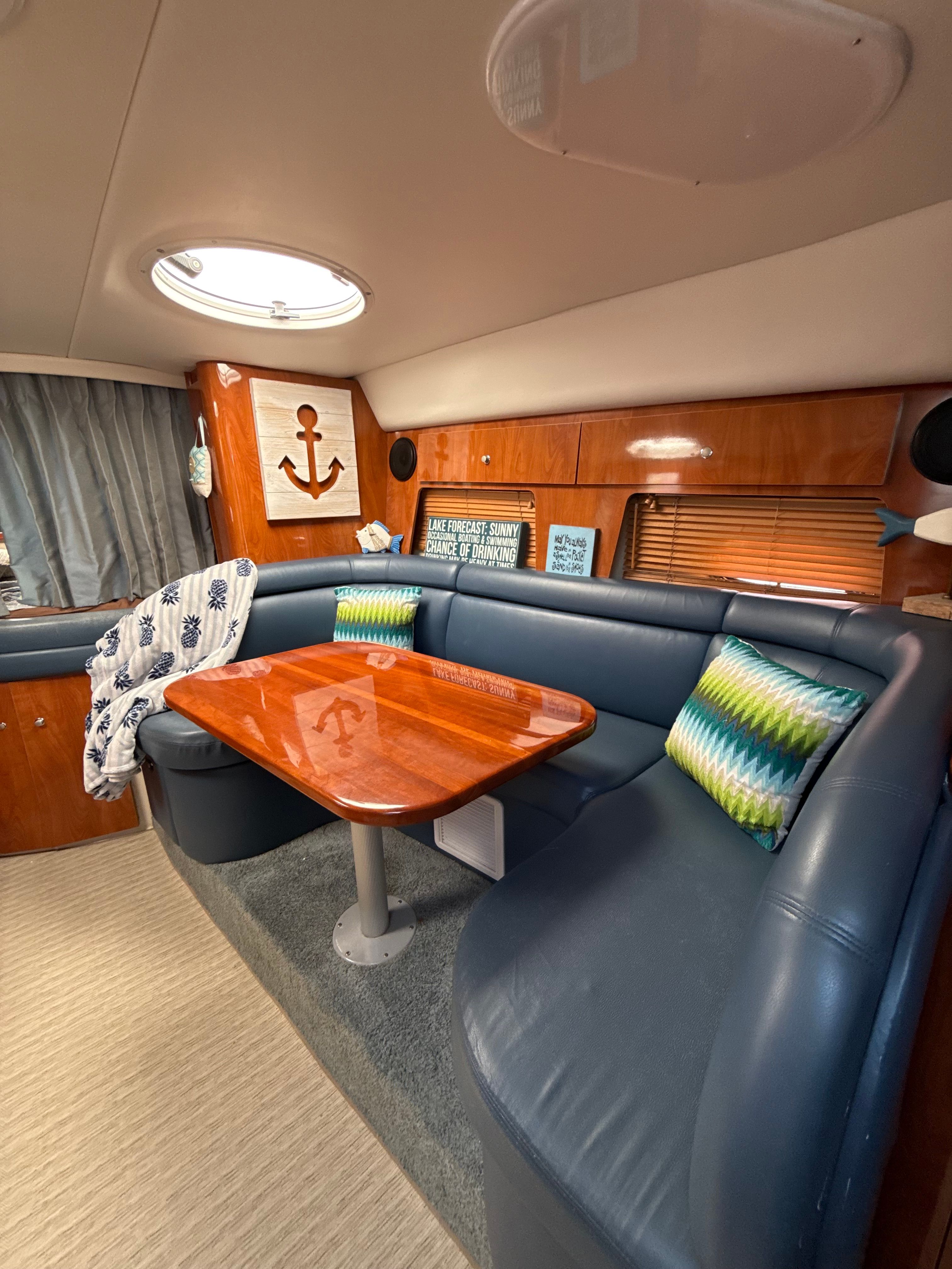 Luxurious 2004 Four 328 Vista yacht interior with plush seating and wooden table.