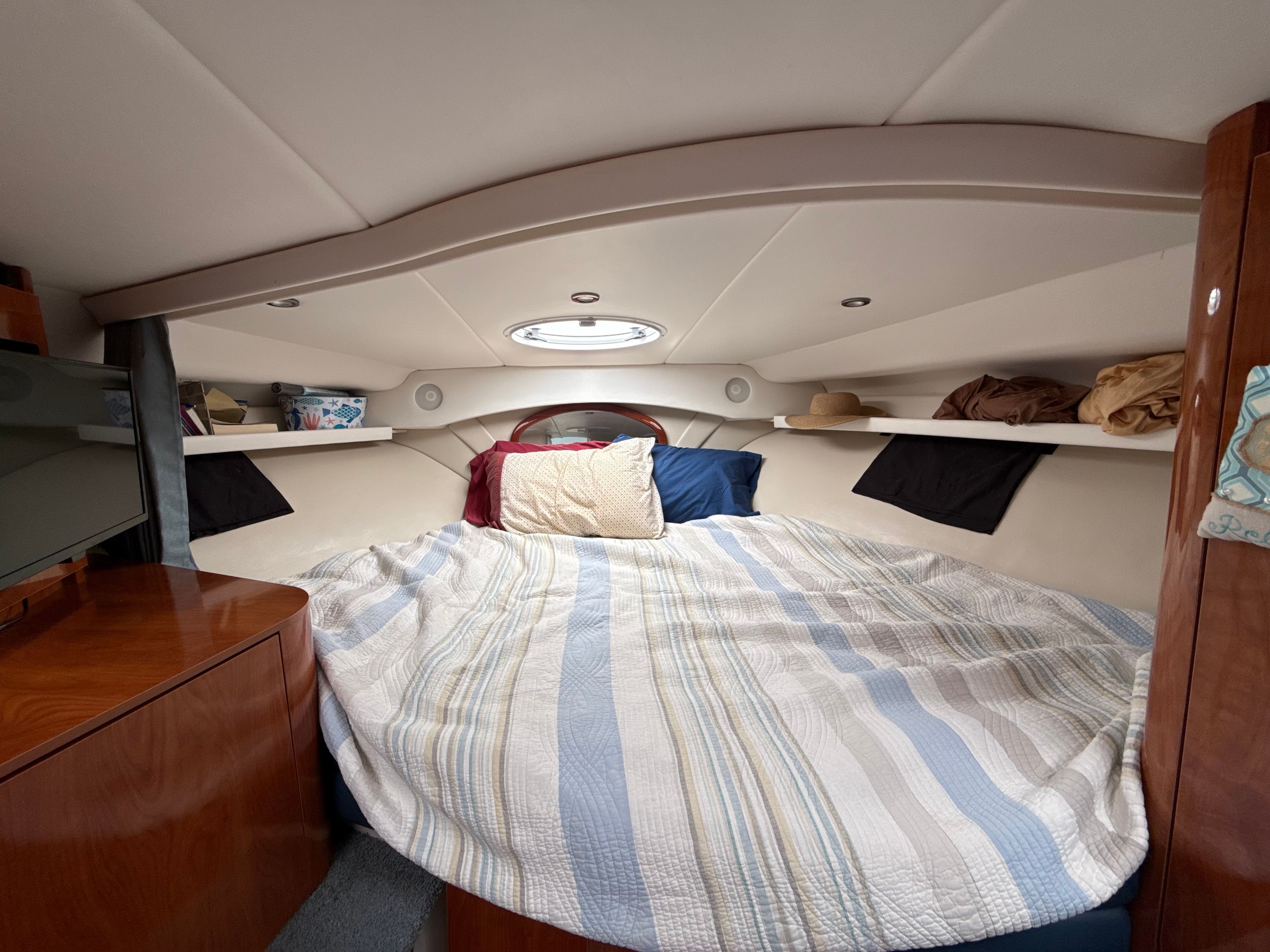 Cozy cabin interior of 2004 Four 328 Vista boat with bed and storage shelves.
