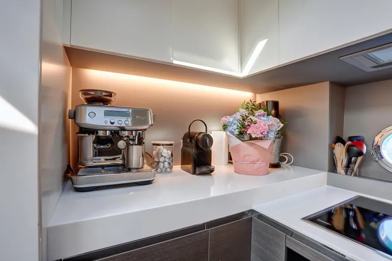 Apricity Yacht Photos Pics Modern kitchen in 2024 Azimut S8 yacht with espresso machine and floral arrangement.