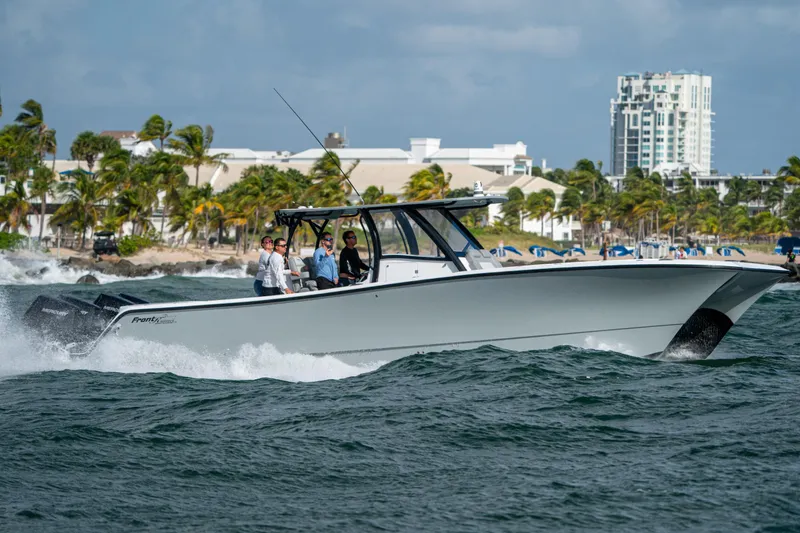  Yacht Photos Pics 2026 Front Runner 37 Catamaran cruising on ocean near coastal cityscape.