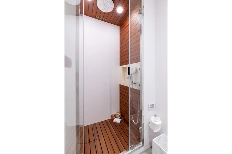 Euphoria Yacht Photos Pics Luxurious shower in 2022 Azimut 78 yacht with wood paneling and modern fixtures.